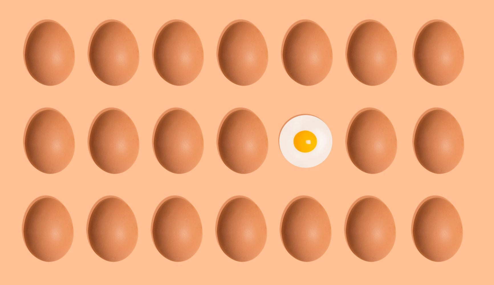 Eggs with a single egg featuring a yellow yolk on an orange background