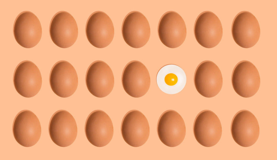 Eggs with a single egg featuring a yellow yolk on an orange background